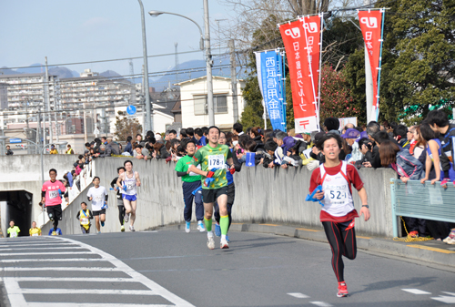 たすきを手に坂道ダッシュ