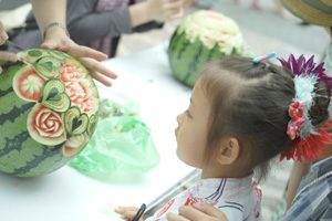 スイカに彫刻した飾りを見つめる子ども